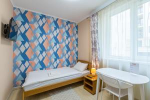 a small room with a bed and a geometric wall at BonApart in Lviv