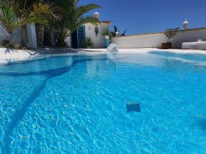 une grande piscine bleue avec un panneau dans l'eau dans l'établissement Villa Adriano, à Sabina Alta