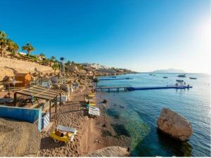 una playa con sombrillas, sillas y agua en Concorde El Salam Sharm El Sheikh Sport Hotel, en Sharm El Sheikh