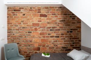 a room with a brick wall and a blue chair at Fani&Rozi B&B in Maribor