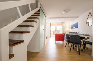 a living room and dining room with a staircase and a table and chairs at Parque Santiago 1 Duplex 2A014 in Playa de las Americas