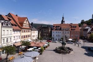 una ciudad con edificios y una calle con sombrillas en Hotel Weißes Ross en Kulmbach