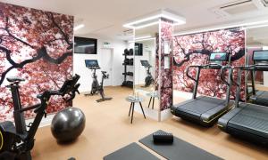 a gym with exercise equipment and a wall mural at The Athenaeum Hotel & Residences in London