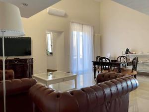 a living room with a leather couch and a television at Santa Lucia B&B in Gaeta