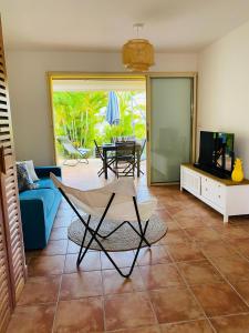 un salon avec un canapé bleu et une télévision dans l'établissement Maison mitoyenne , piscine,Citerne, jardin, parking, plage, au Gosier