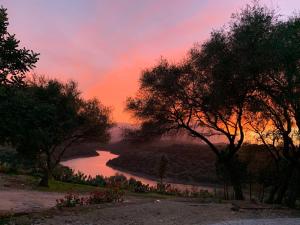 a view of a river at sunset with trees at Hotel Villa Cedrino in Dorgali