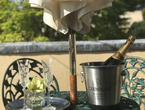 a bottle of champagne in a bucket on a table with glasses at Coombe House in Bourton on the Water