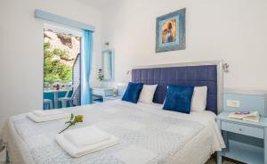 a blue and white bedroom with a large bed at Klima Rooms in Palaiochora