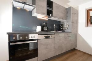 a kitchen with stainless steel cabinets and a stove at Apart Alpina Huben in Längenfeld