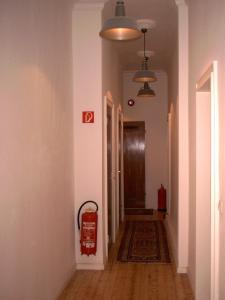 an empty hallway with a fire extinguisher on the wall at Buch-Ein-Bett Hostel in Hamburg