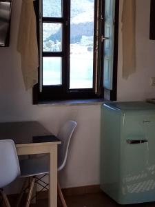 Habitación con escritorio, ventana y mesa. en Traditional Apartments Plagiaki, en Neon Oitilon