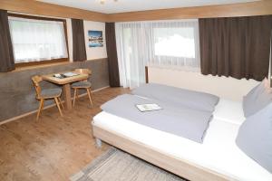 レンゲンフェルトにあるApart Alpina Hubenのベッドとテーブルが備わるホテルルームです。