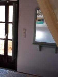 una puerta abierta a una habitación con espejo en Traditional Apartments Plagiaki, en Neon Oitilon