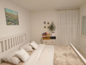 um quarto com uma cama com lençóis brancos e almofadas em The 2Sisters Suite em Zadar