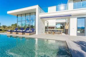 una casa con piscina di fronte a una casa di Villa Montchavin a Quinta do Conde