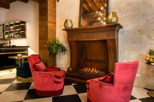 a lobby with red chairs and a fireplace at Corte Guelfa in Florence