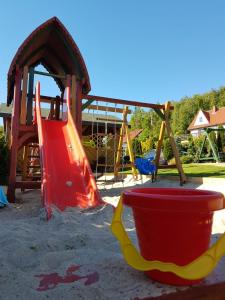 a playground with a slide and a bucket at Willa na wzgórzu in Rusinowo
