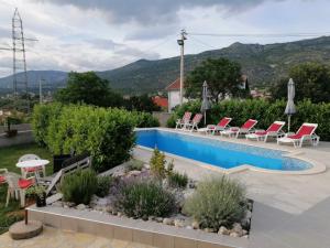 a swimming pool with lounge chairs and a pool at Villa Panorama Blagaj in Blagaj