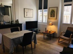 un salon avec une table et une télévision dans l'établissement Joli et agréable studio, à Bordeaux