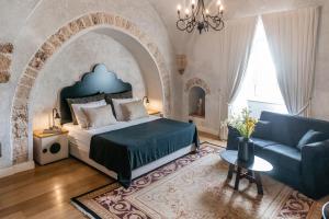 sypialnia z dużym łóżkiem i kanapą w obiekcie Casa Nova - Luxury Suites & Boutique Apart-Hotel w Tel Awiwie