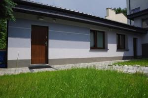 a white and blue house with a brown door at Niedaleko od Centrum ale Z dala od tłumów in Lublin