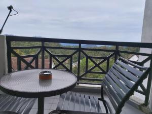 a table and a bench on a balcony at FH Comfy Home in Bukit Fraser