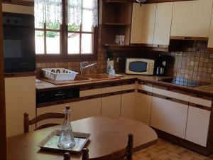 a kitchen with a table and a sink and a microwave at La Quietude in Amboise