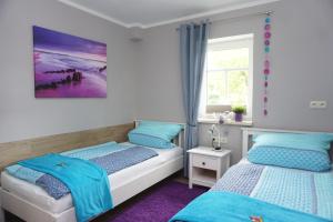 a bedroom with two beds and a window at Ferienwohnung am Dorfplatz in Kurort Gohrisch