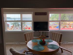 una sala da pranzo con tavolo, sedie e finestre di Tiki Beach Condo 1 a Campbellsport