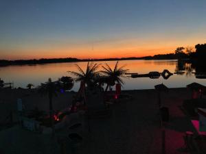 un tramonto su un lago con una barca in acqua di Tiki Beach Condo 1 a Campbellsport