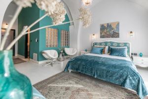 Casa Nova - Luxury Suites & Boutique Apart-Hotel في تل أبيب: غرفة نوم بسرير ازرق و مزهرية