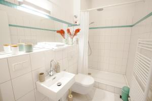 a white bathroom with a toilet and a sink at Family-friendly Waterfront Loft, 3 Bedrooms, 130 m2 in Berlin
