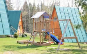a playground with a house and a slide at Chatky Sázava in Sázava