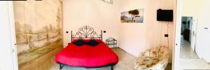 un grande letto rosso in una stanza con una sedia di Casa Nina ad Agerola