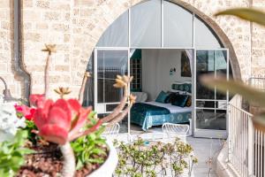 um quarto com uma cama e um quarto com flores em Casa Nova - Luxury Suites & Boutique Apart-Hotel em Tel Aviv