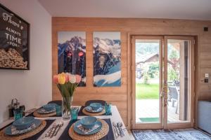 ein Esszimmer mit einem Tisch mit Platten und Blumen in der Unterkunft Résidence Le Green in Chamonix-Mont-Blanc