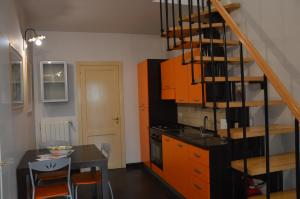 a kitchen with orange cabinets and a table and a staircase at B&B Al cortiletto Modica centro in Modica +37 photos