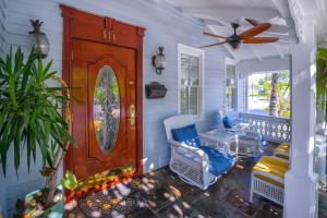 a front door of a house with chairs and a fan at Duval Inn - Key West in Key West