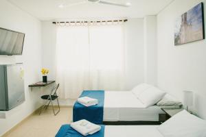 a white room with a bed and a tv at Hotel Tucuraca by DOT Tradition in Santa Marta