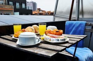 a table with breakfast foods and drinks on a balcony at Hotel Girassol in Porto