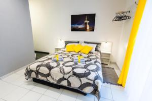 - une chambre avec un lit et des oreillers jaunes dans l'établissement BLACK & YELLOW Centrally located studio, à Novi Sad