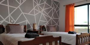 een slaapkamer met 2 bedden en een geometrische muur bij Holiday House in Albufeira +10 foto's