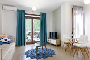 Armenos Elegance Apartments في إيريسوس: غرفة معيشة مع أريكة وطاولة