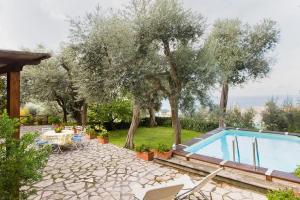 a swimming pool in a yard with trees and a patio at Villa Stella in Massa Lubrense