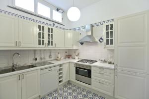 a white kitchen with white cabinets and a sink at Villa Stella in Massa Lubrense