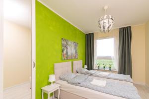 een groene slaapkamer met een bed en een raam bij Apartament Zdrojowa 58m2 in Grójec
