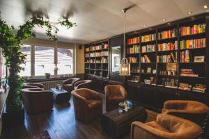 モンシャウにあるホテル デ ランゲ マン モンシャウ アイフェルの革張りの椅子と本棚のある図書室