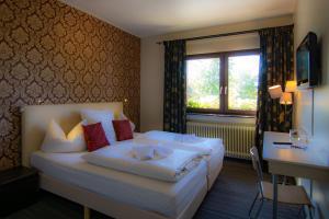 a hotel room with a bed and a window at Hotel De Lange Man Monschau Eifel in Monschau
