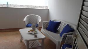 マルサラにあるCasa Vacanze Escondidoの椅子2脚、テーブル、青い枕が備わる客室です。