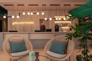 チューリッヒにあるSorell Hotel St. Peterの椅子二脚の男